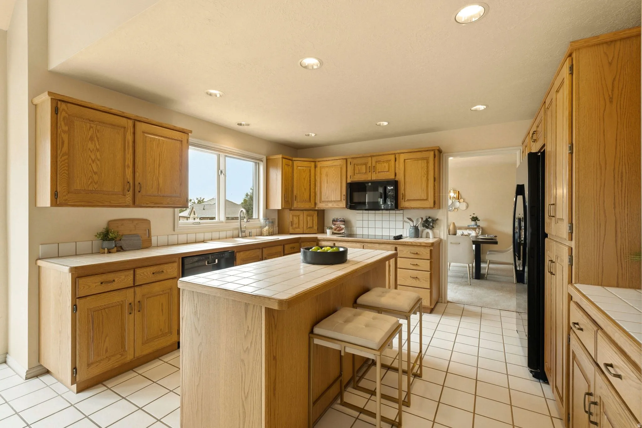 Kitchen featuring wood cabinetry, white tile flooring, recessed lighting, and a center island with bar seating