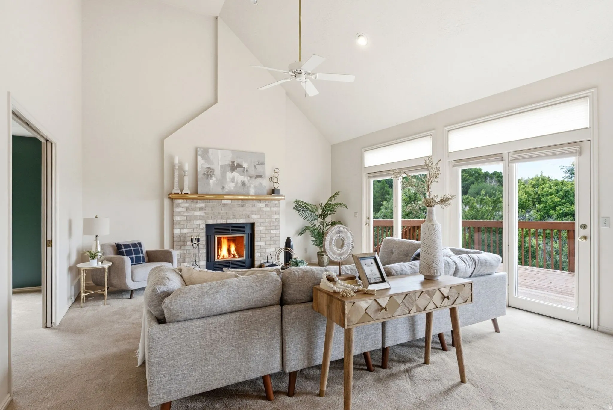 Vaulted living room with a brick fireplace and a wood mantelpiece