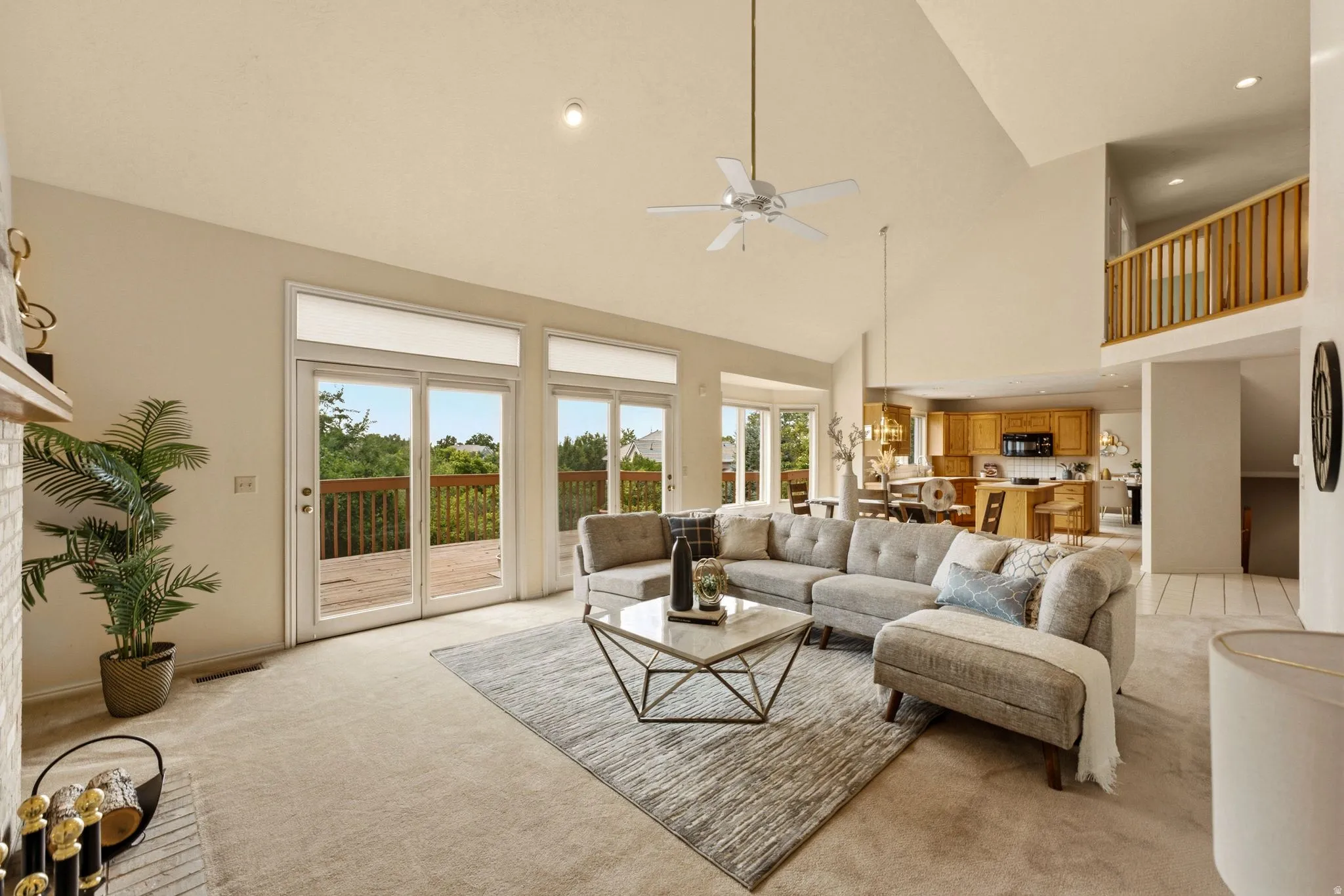 Vaulted ceilings, a ceiling fan, and a fireplace with a brick surround