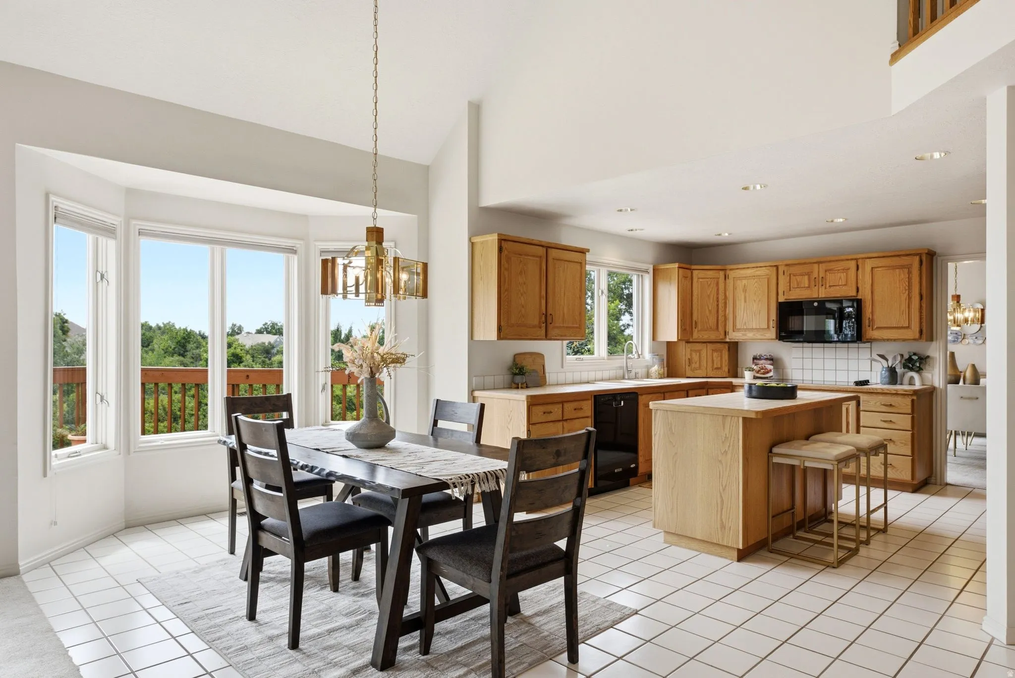 Open-concept kitchen and dining area featuring light wood cabinetry and white square tile flooring