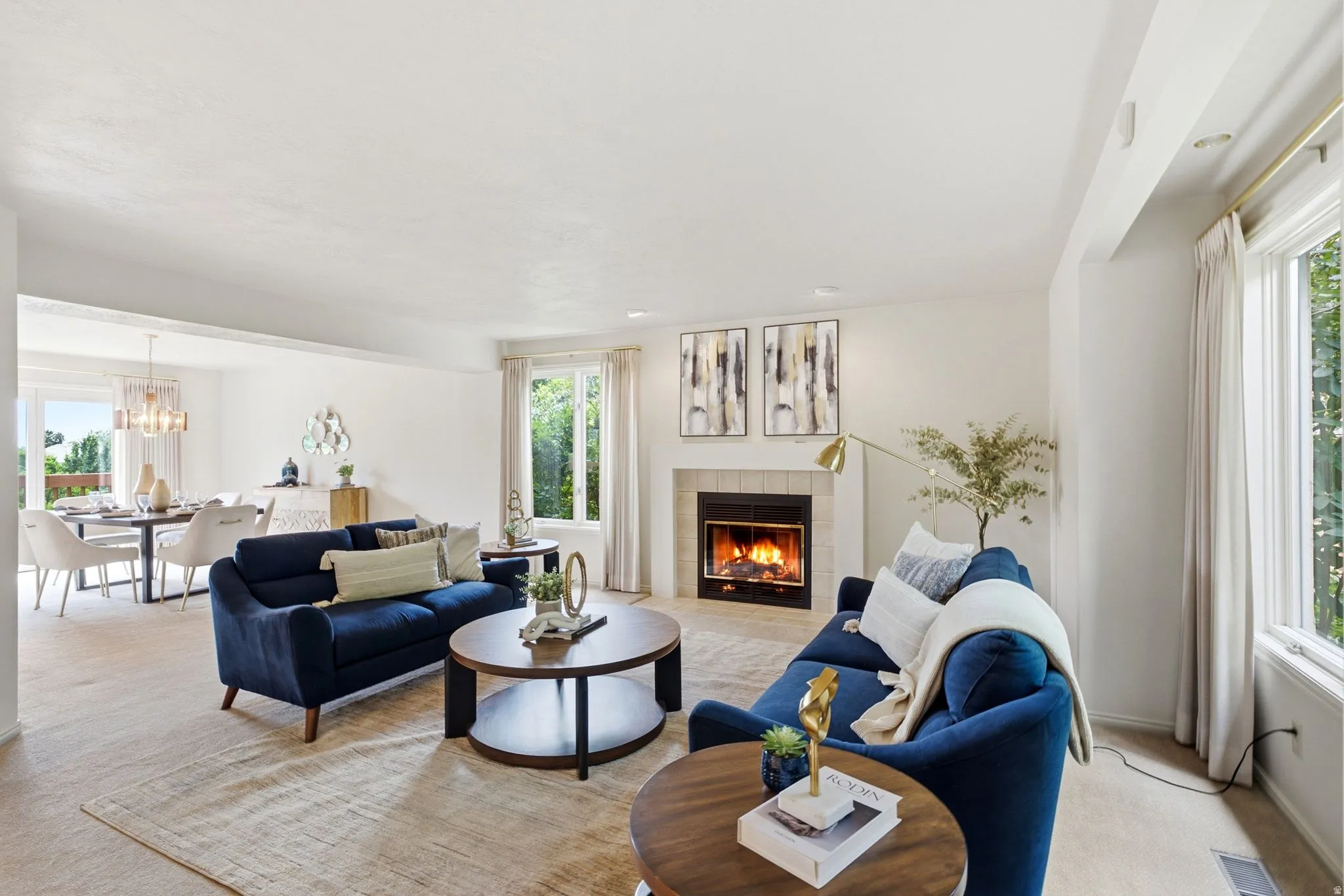 Living area featuring a fireplace with a tiled surround, recessed lighting, and large windows