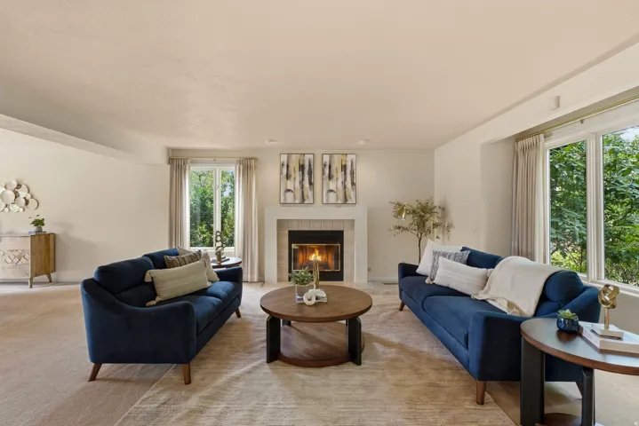 Recessed lighting, wood-burning fireplace with tile surround, expansive windows, and light-toned carpeting throughout