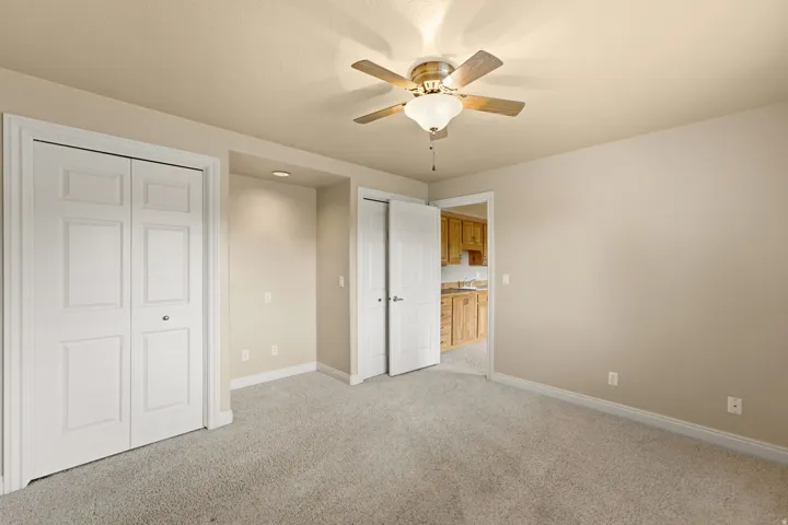 Recessed lighting illuminates an alcove, complementing the overhead ceiling fan with light fixture