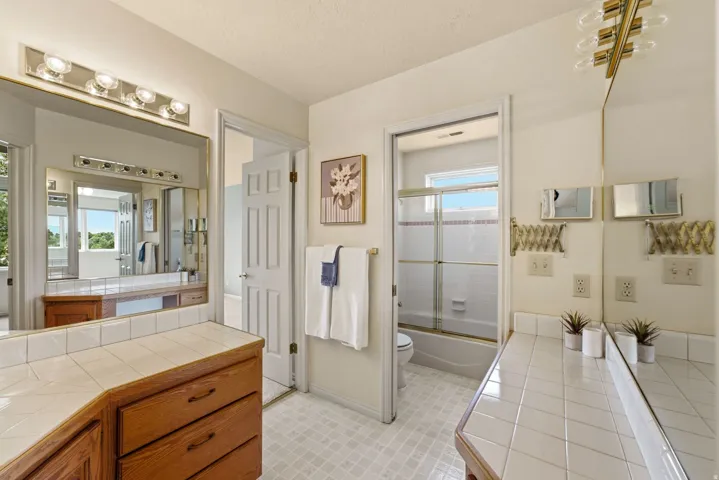Double vanity with tile countertops and wood-finish cabinetry
