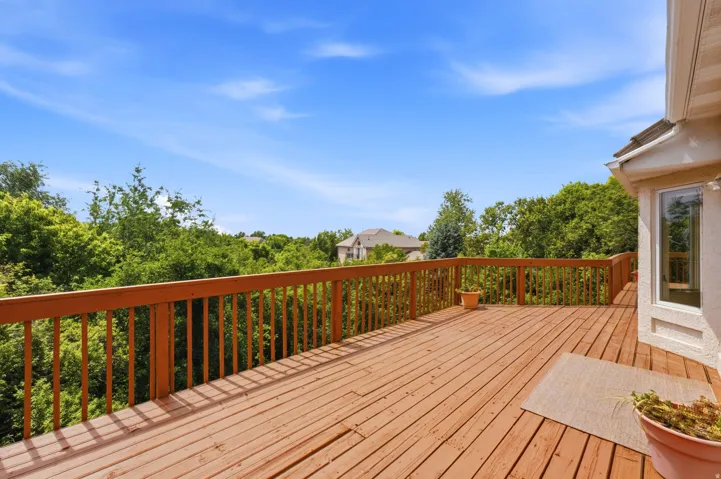 Expansive wood deck with natural wood railing, offering abundant outdoor living space