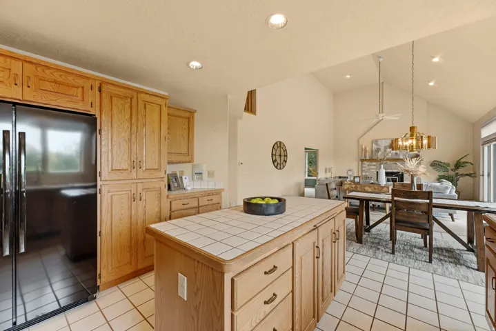 Kitchen featuring wood cabinetry, tile flooring, and a tile-topped island