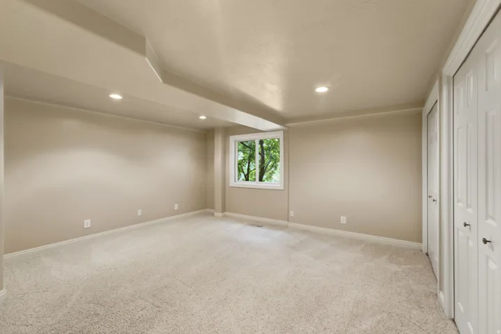 Recessed lighting, neutral-toned walls, and soft pile carpeting