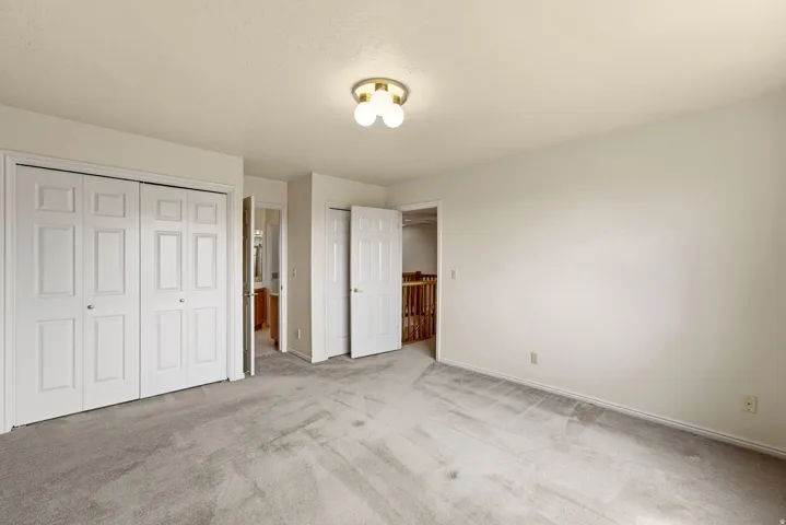 Recessed lighting, light-toned carpeting, white bi-fold closet doors, white paneled doors, and light-toned walls