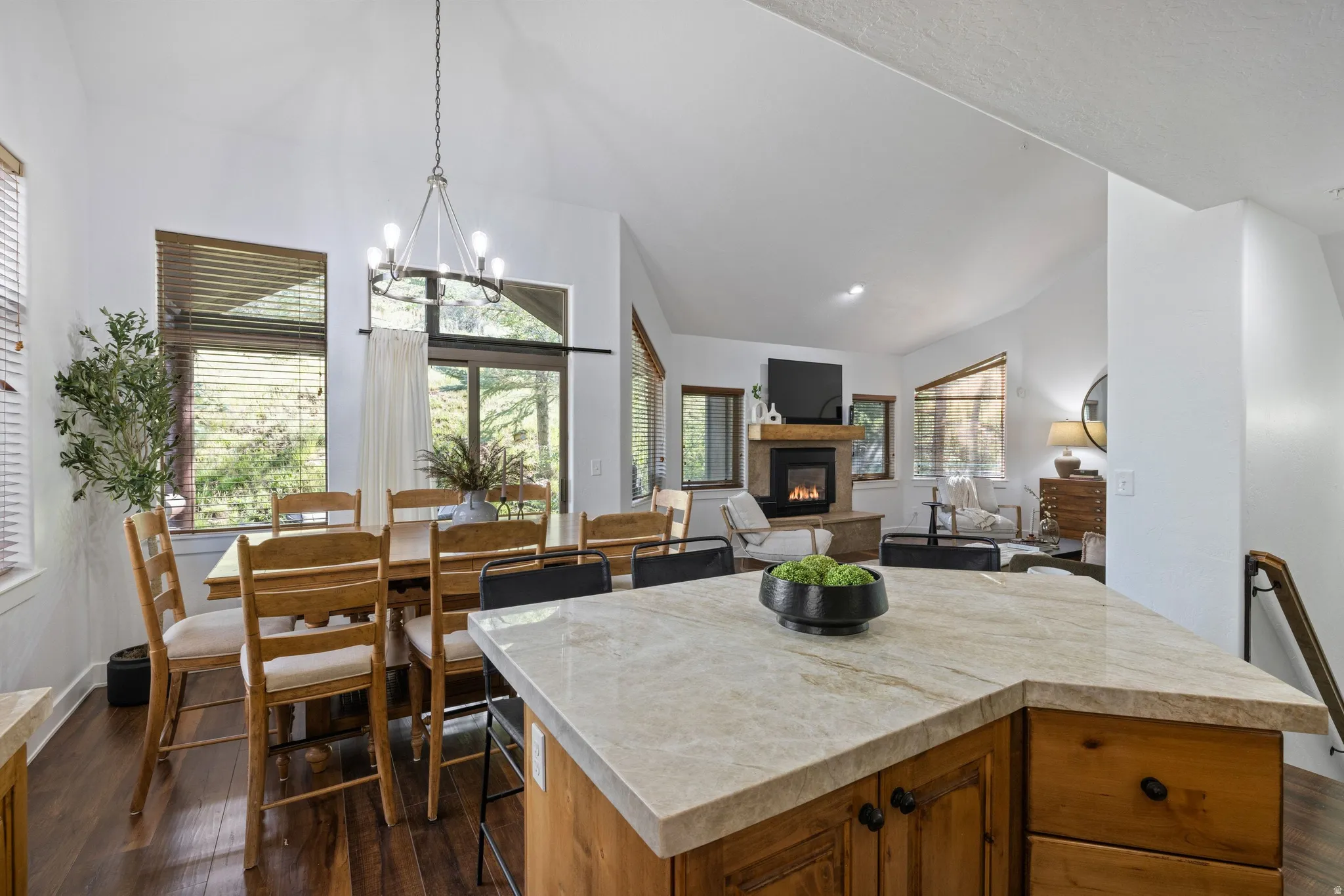 Open-concept living space featuring vaulted ceilings, wood-finish flooring, and ample natural light