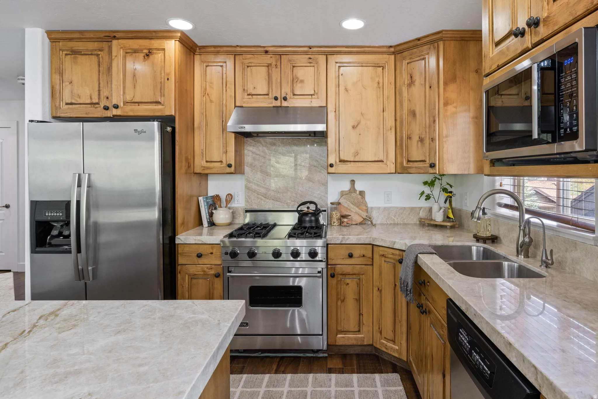 Kitchen featuring wood-finish cabinetry, light-toned countertops, and a stainless steel appliance suite