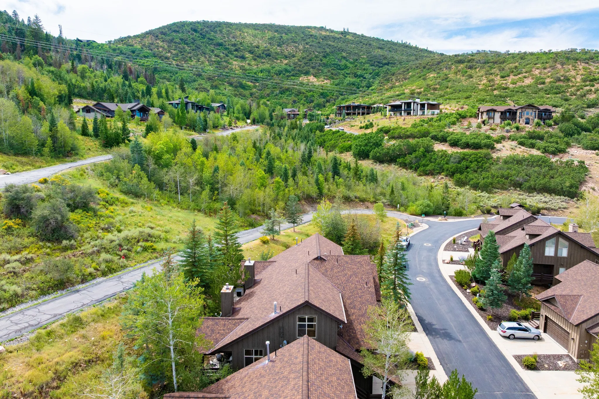 Mountainous terrain featuring multiple residential structures and paved roadways