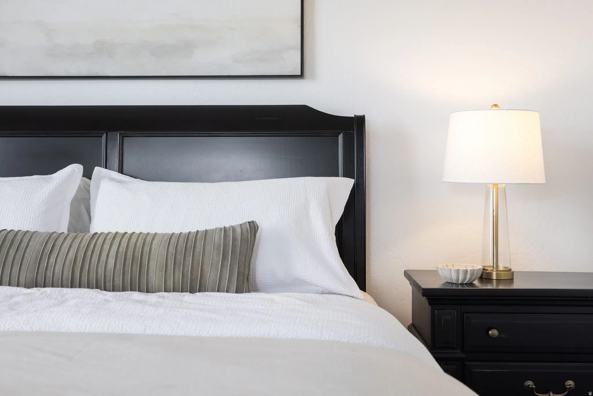 Classic black paneled headboard with an accompanying black nightstand featuring traditional hardware