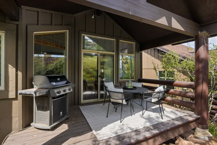 Inviting outdoor deck featuring a wood-finish floor, wood railing, and a covered ceiling