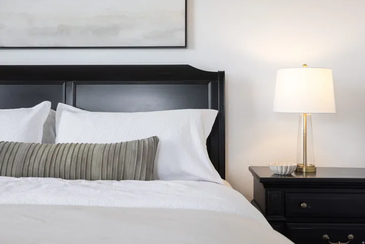 Classic black paneled headboard with an accompanying black nightstand featuring traditional hardware