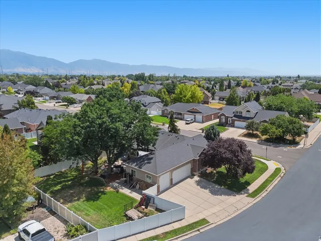 Suburban neighborhood setting featuring a single-story residence with a dark roof and a two-car garage