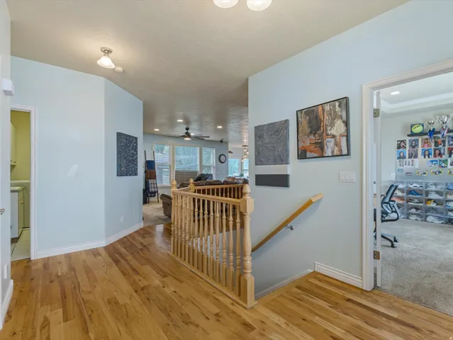 Hardwood flooring throughout the main level featuring a light wood railing and painted walls