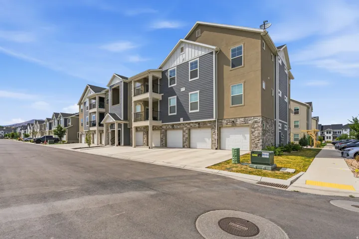 Multi-level townhome exterior featuring stone veneer, horizontal siding, and multiple balconies