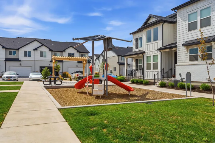 Recreational playground area featuring slide and climbing elements set on wood chip surfacing