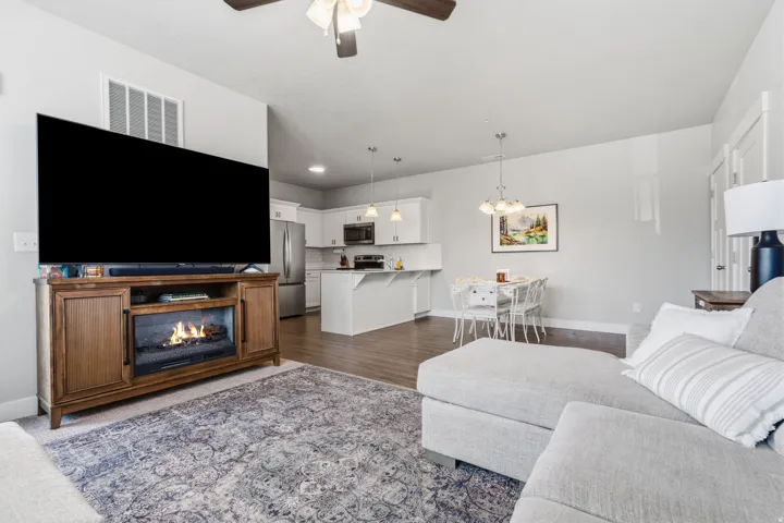 Open-concept living space with wood-finish flooring extending to the kitchen and dining areas