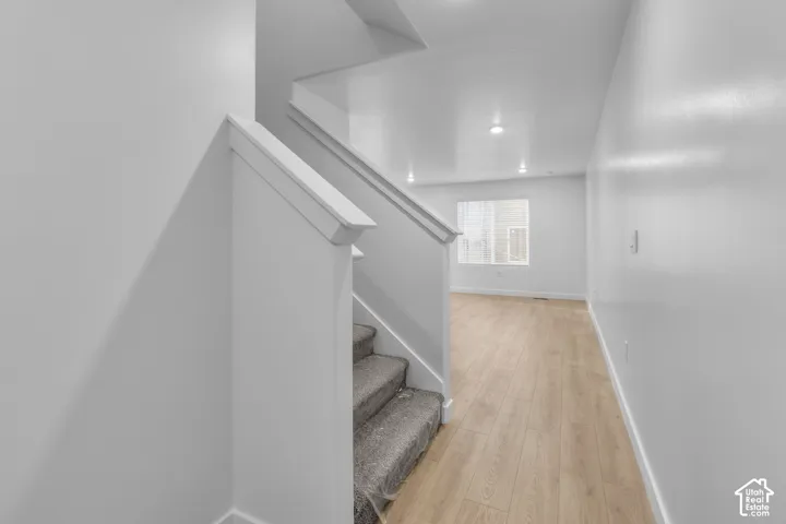 Staircase with carpeted treads and white wood railing
