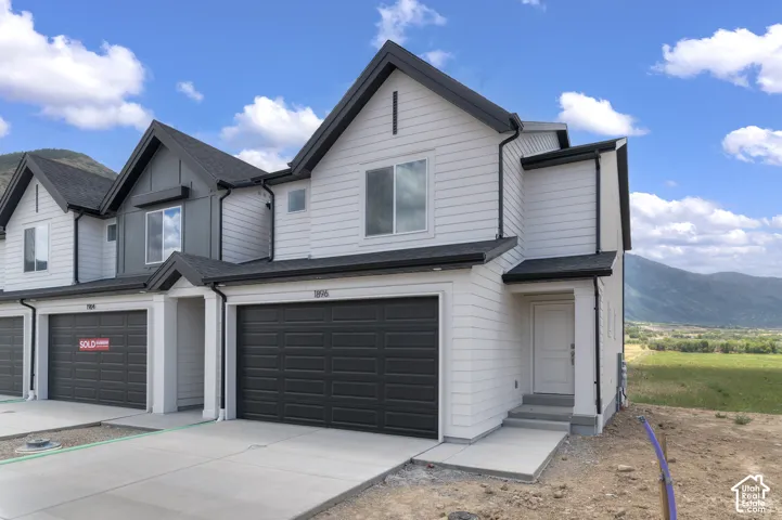 Contemporary facade featuring horizontal white siding with dark trim accents