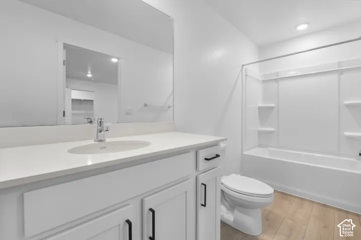 White shaker vanity with black hardware, an undermount sink, and a light-colored countertop