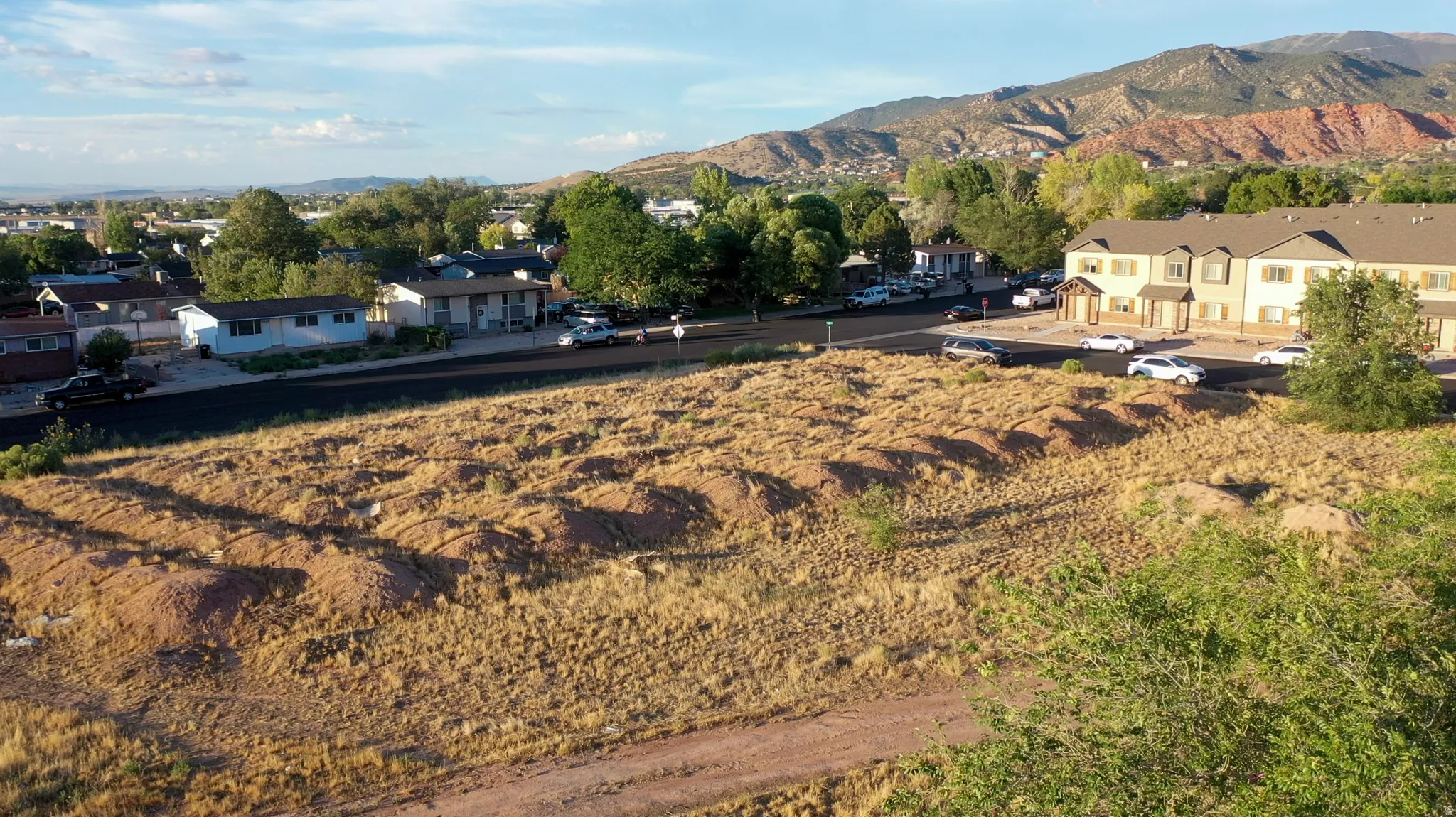 Expansive undeveloped lot with natural ground cover, offering a prominent position within a residential setting
