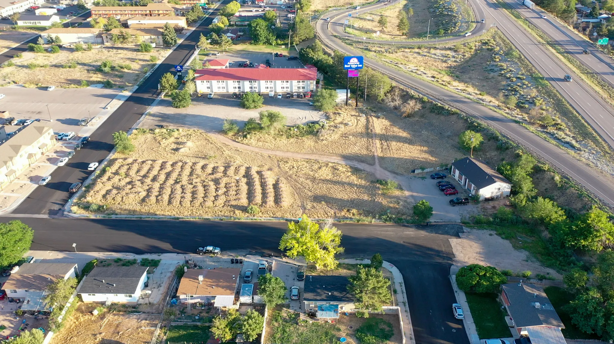 Expansive land parcel featuring new asphalt paving and surrounding commercial structures