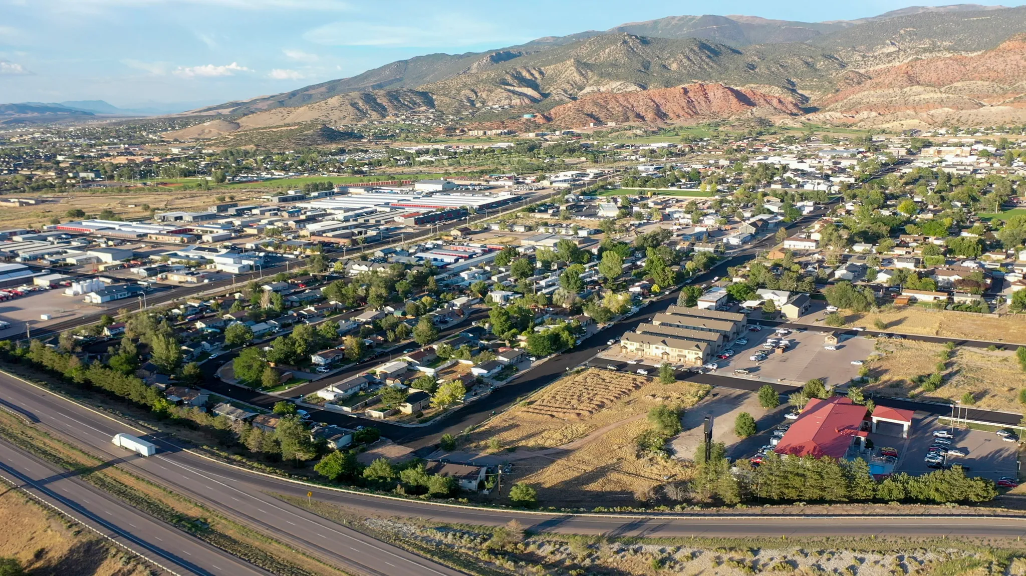 Aerial perspective showcasing a mixed-use community with residential areas, commercial buildings, and extensive roadways