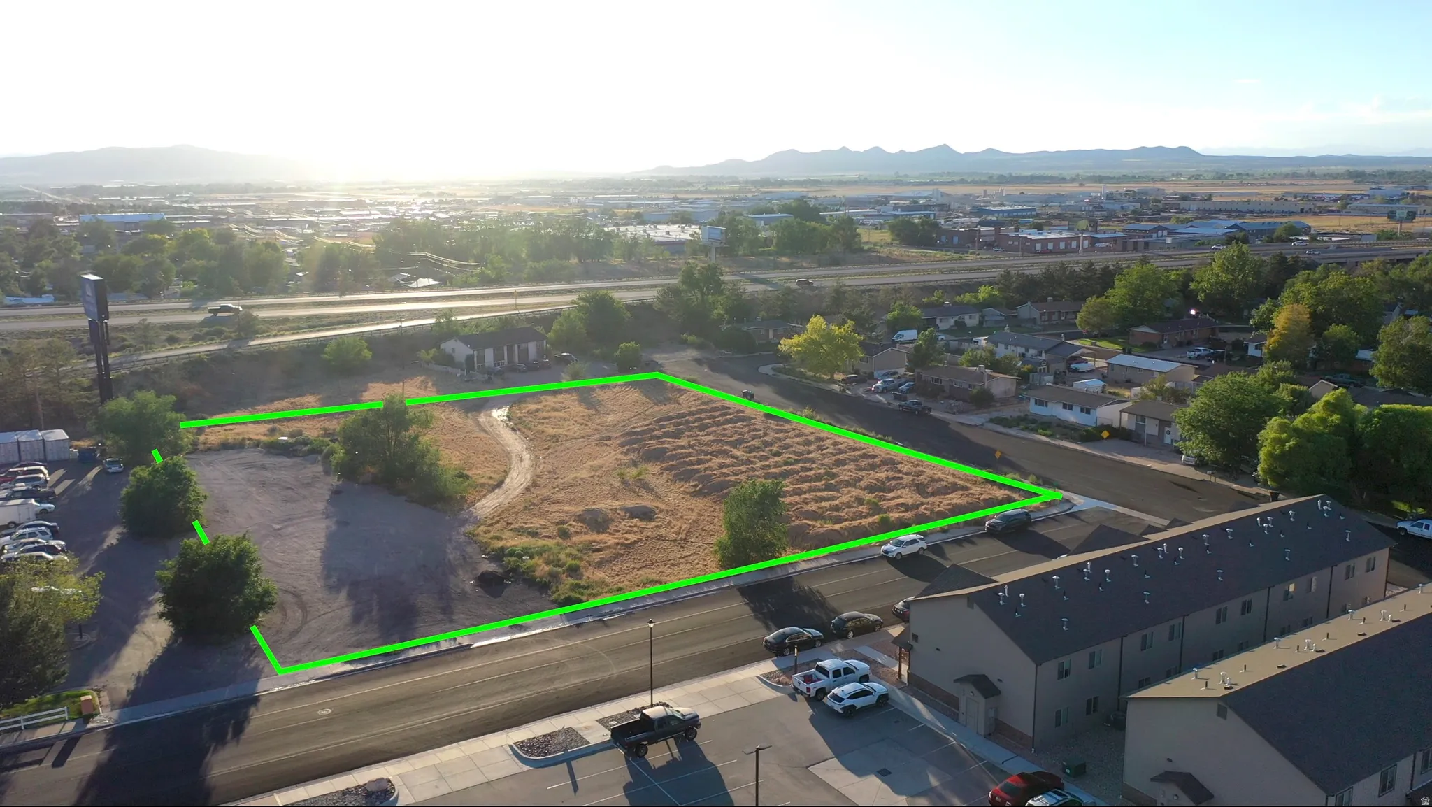 Expansive parcel featuring a large undeveloped area, a paved road frontage, and a partially graveled section