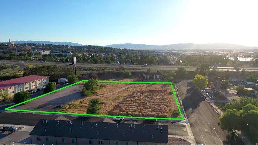 Expansive land parcel featuring existing paved areas and natural ground cover