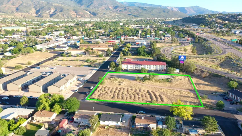 Expansive land parcel featuring direct road frontage and visible mountain backdrops