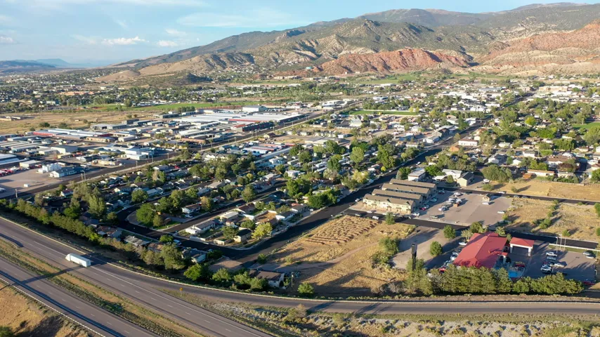 Aerial perspective showcasing a mixed-use community with residential areas, commercial buildings, and extensive roadways