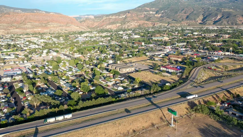 Expansive aerial perspective showcasing a residential community with abundant mature trees and a highway system