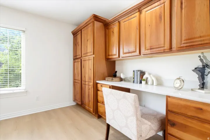 Built-in wood cabinetry with extensive storage, integrated desk space, and a white countertop