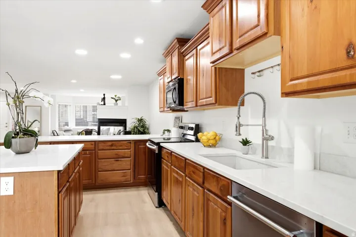 Kitchen featuring wood cabinetry, light-toned countertops, and a white tile backsplash