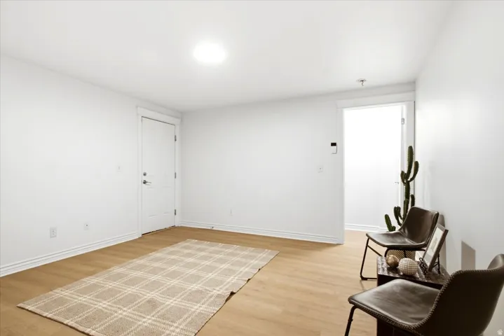 Bright interior space featuring light wood-finish flooring, white walls, and a recessed ceiling light fixture
