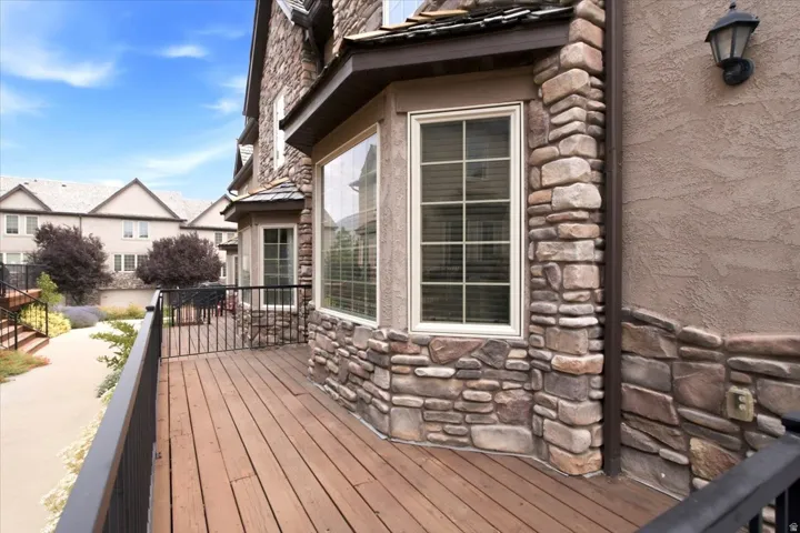 Spacious outdoor deck featuring wood flooring and black metal railings