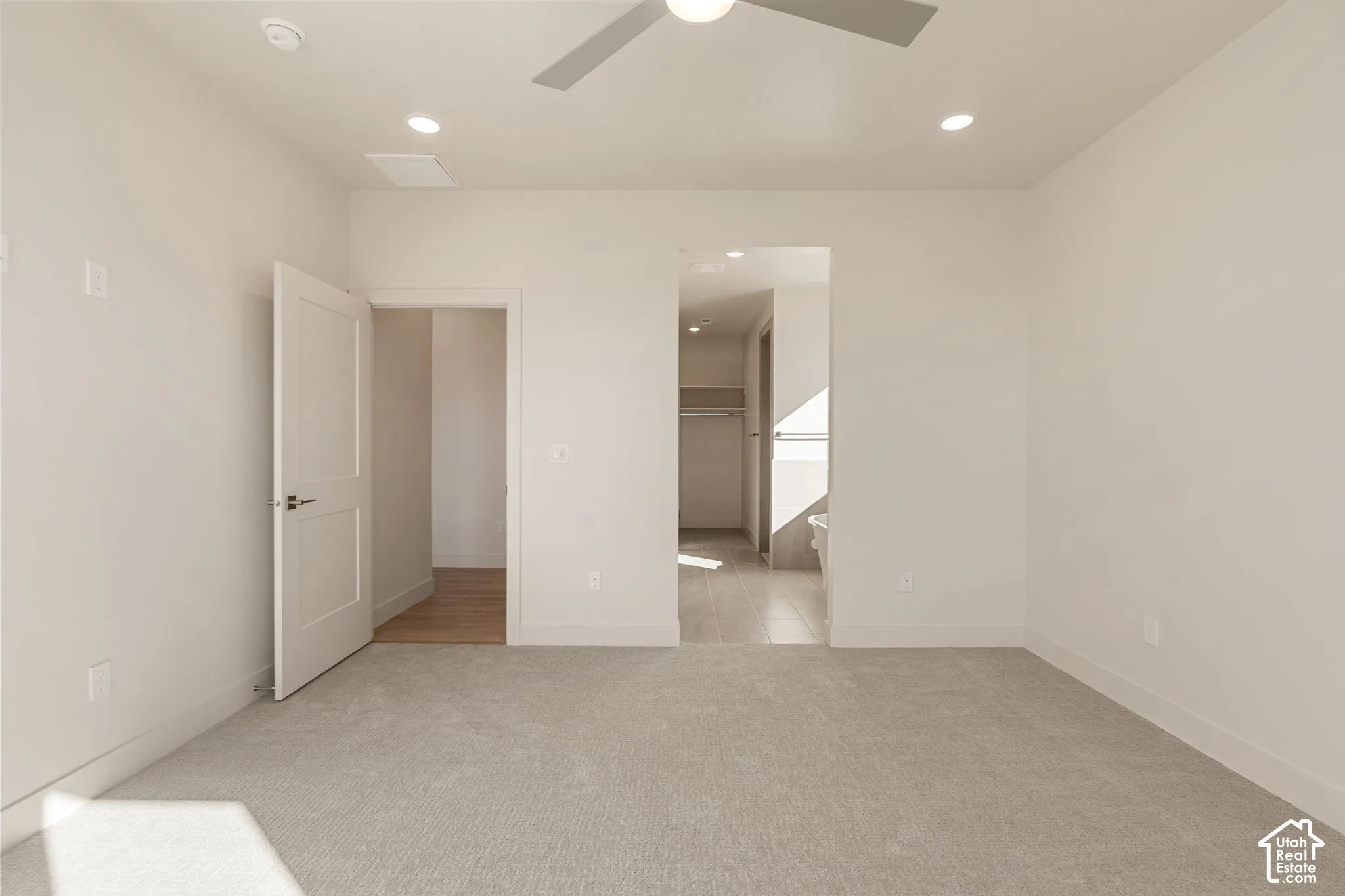 Neutral interior space featuring neutral carpeting, recessed lighting, a modern ceiling fan, and multi-panel interior doors