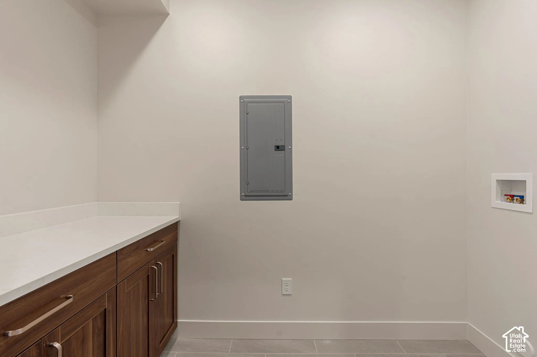 Custom cabinetry with wood-finish doors, solid-surface countertop, and integrated utility connections