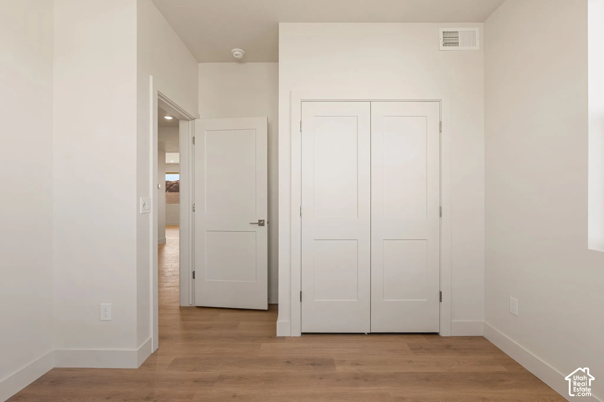 Wood-finish flooring, two-panel interior doors, and a double-door closet with recessed paneling