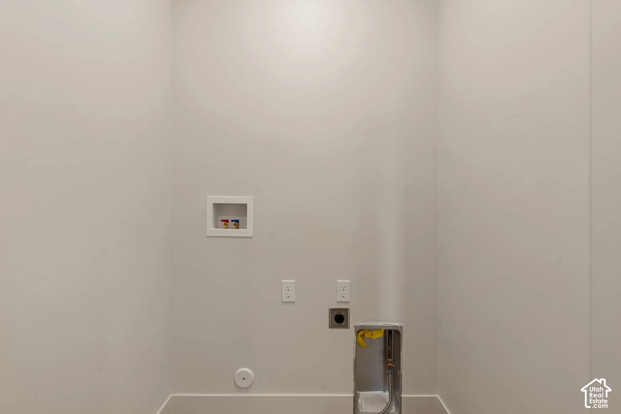 Dedicated utility space featuring laundry hookups, electrical outlets, and a vent connection