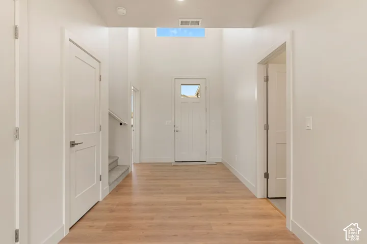 Entryway featuring high ceilings, wood-finish flooring, a transom window, and paneled interior doors