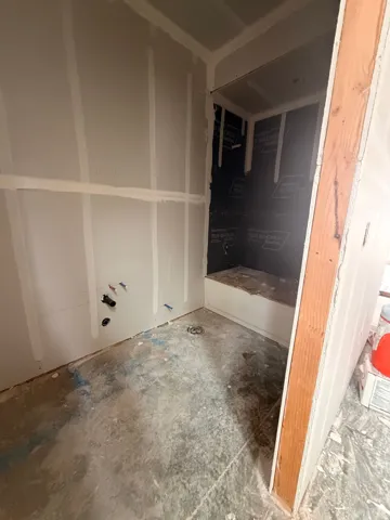 Rough-in plumbing for a future vanity and shower with visible water lines and drain