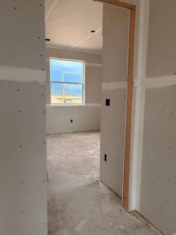 Unfinished interior space featuring drywall installation and a white-framed window