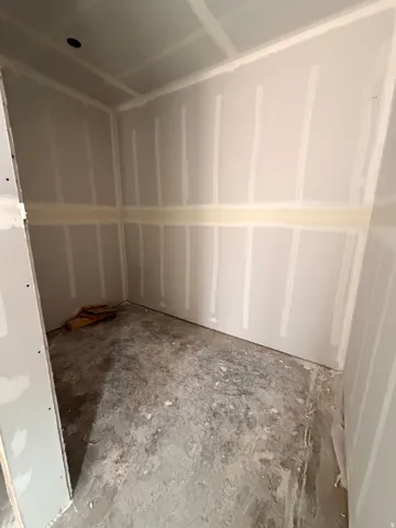 Interior space featuring drywall installation and concrete flooring