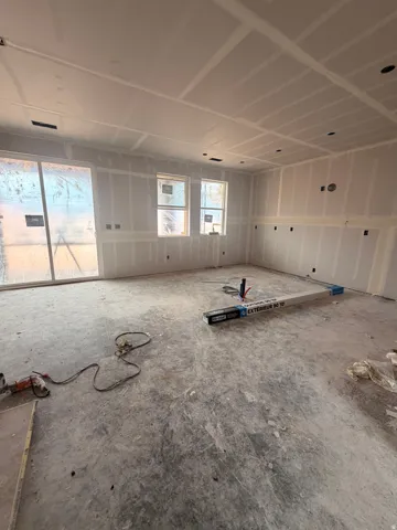 Spacious interior room with newly installed drywall