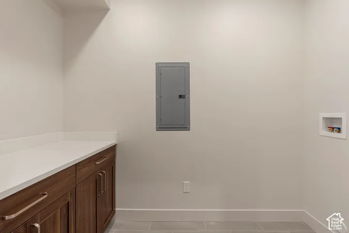Custom cabinetry with wood-finish doors, solid-surface countertop, and integrated utility connections