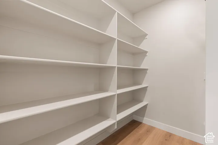 Custom built-in shelving featuring white laminate finish and wood-finish flooring
