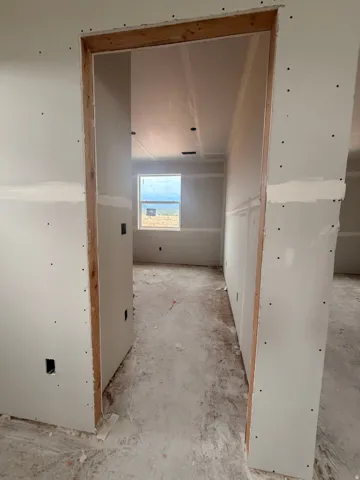 Interior space in construction phase with drywall installed on walls and ceiling
